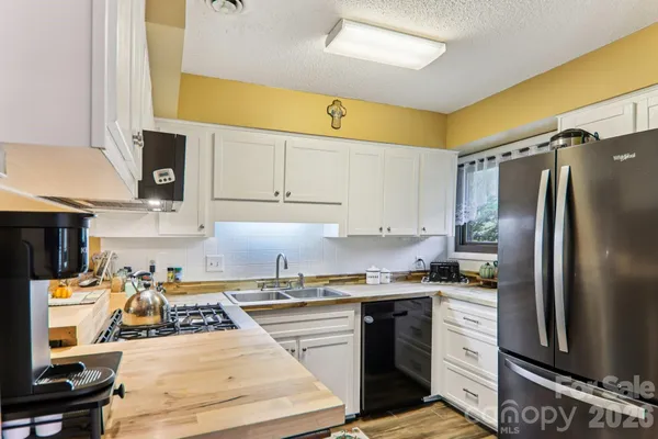 a kitchen with stainless steel appliances granite countertop a sink stove and white cabinets