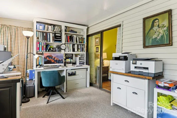 a view of a workspace with furniture and a book shelf