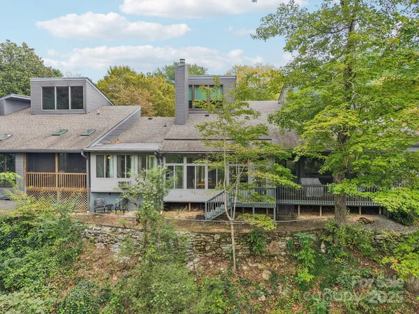 a view of a house with brick walls and a yard with plants