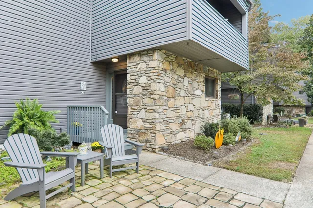 a brick building with a bench and potted plants