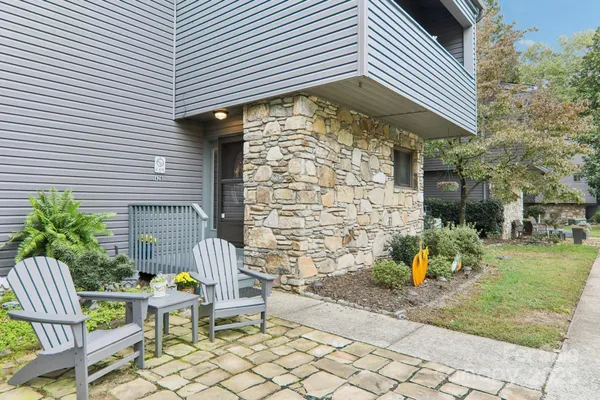 a brick building with a bench and potted plants