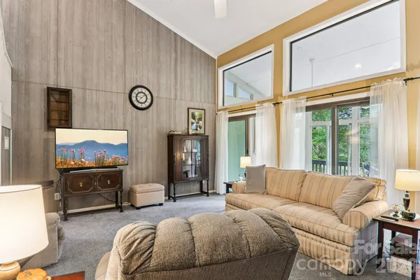 a living room with furniture a fireplace and a floor to ceiling window