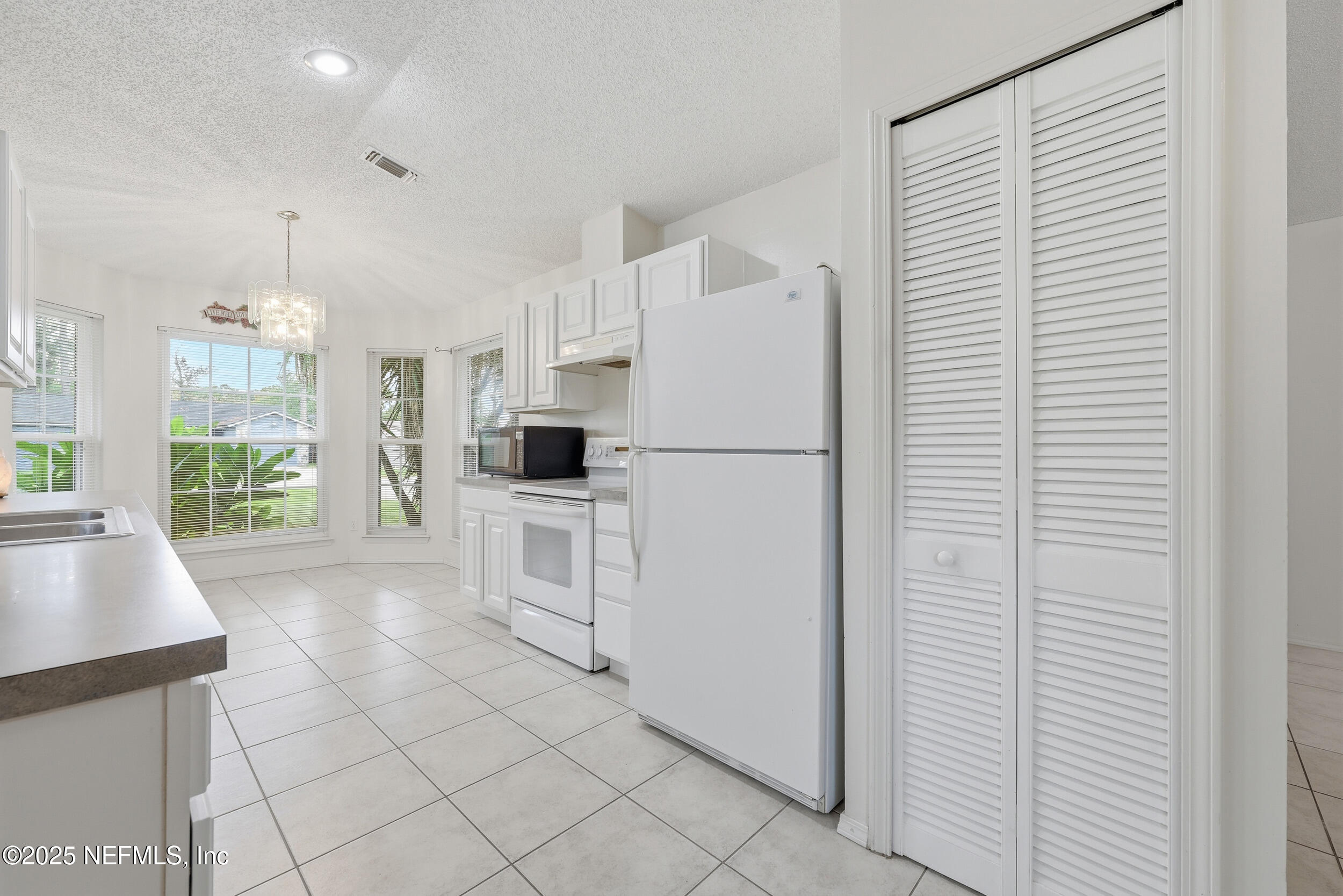 1828 Killarn Circle Middleburg, FL 32068 - Photo 16 of 28 a kitchen with white cabinets and white appliances