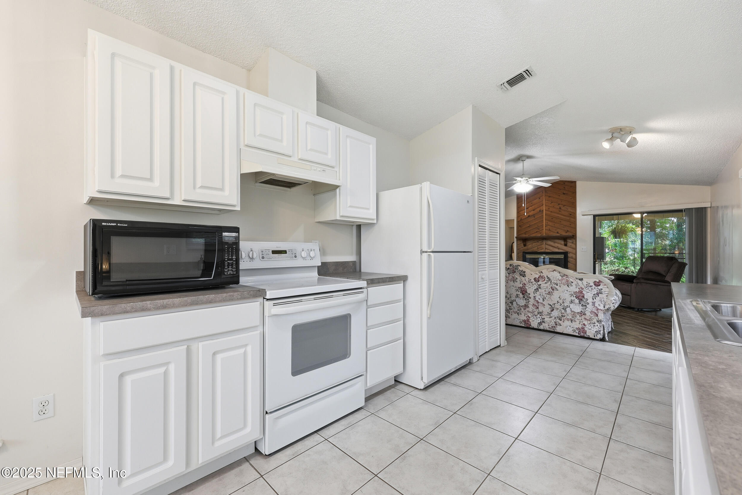 1828 Killarn Circle Middleburg, FL 32068 - Photo 19 of 28 a kitchen with stainless steel appliances a refrigerator sink stove and white cabinets