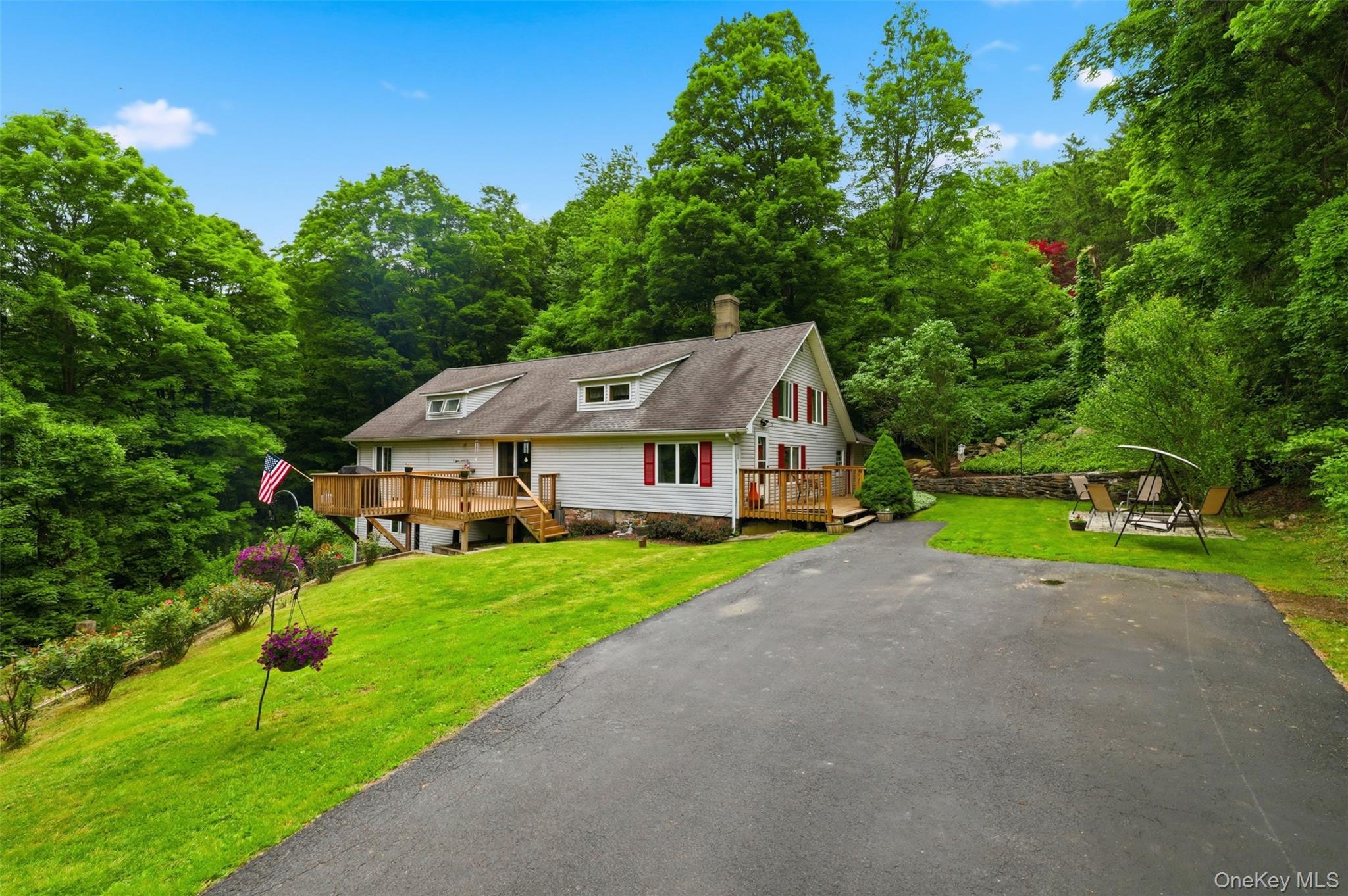 236 Hosner Mountain Road Hopewell Junction, NY 12533 - Photo 5 of 46 Residence featuring a white exterior with red shutters, a prominent wood deck, and a recently-sealed asphalt driveway