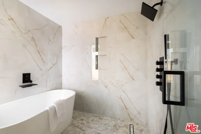 a bathroom with a bathtub sink and mirror