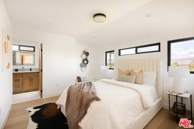 a bedroom with a bed and a mirror on the dresser