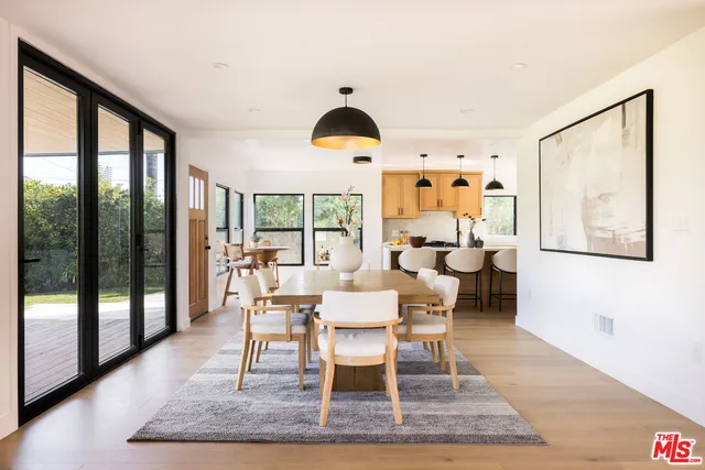 a dining room with wooden floor and white walls
