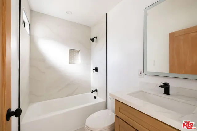 a bathroom with a sink toilet vanity and shower