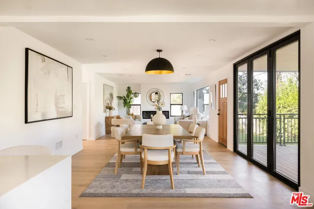 a dining room with wooden floor and white walls