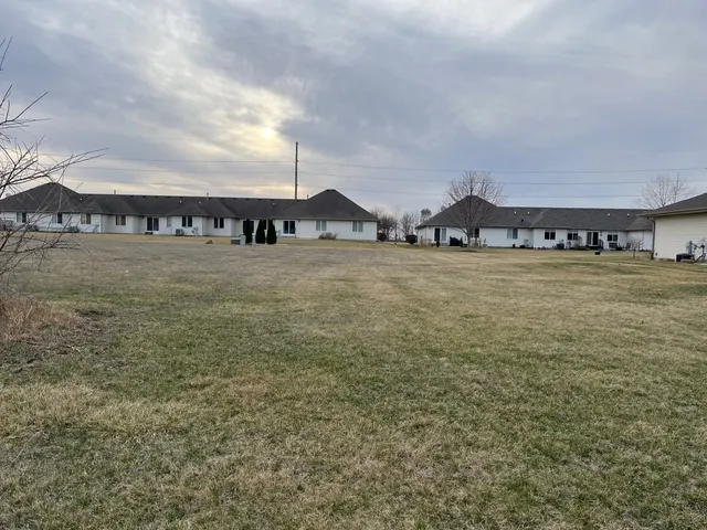 a view of a big house with a big yard and large trees