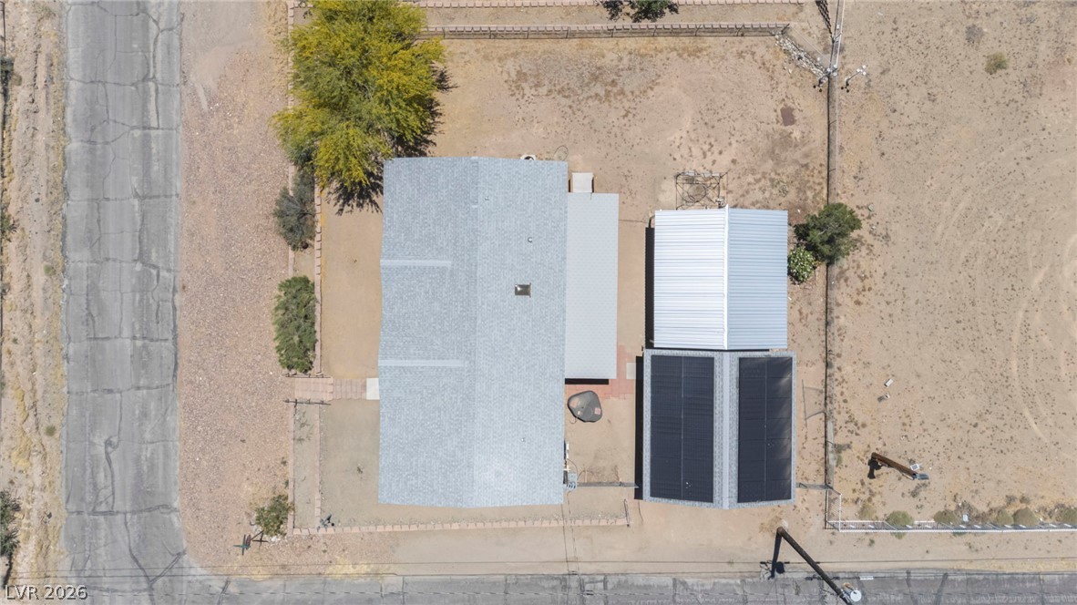 225 California Street Searchlight, NV 89046 - Photo 57 of 64 An aerial perspective reveals the property's layout, showcasing the roofline and surrounding undeveloped land.