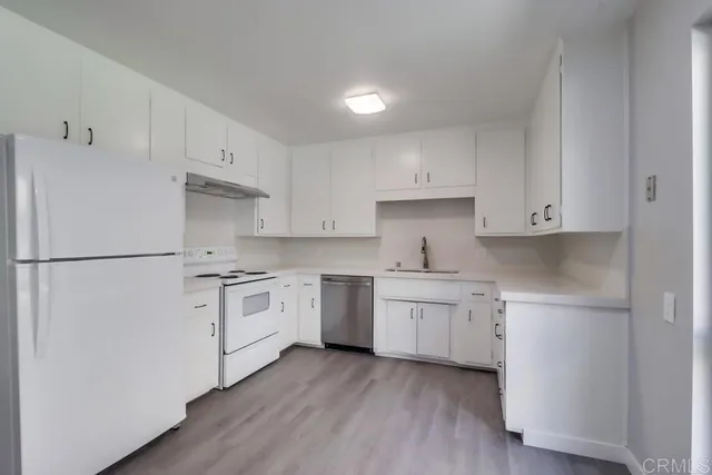 a kitchen with white cabinets and white appliances