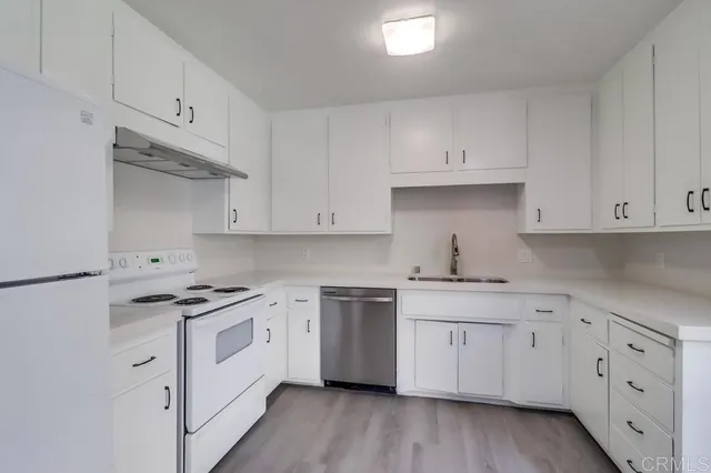 a kitchen with cabinets stainless steel appliances and wooden floor