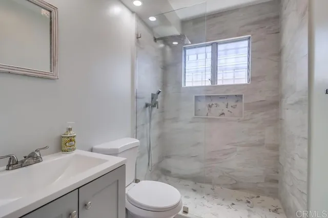 a bathroom with a sink toilet a mirror and shower