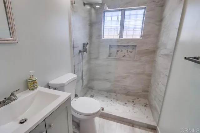 a bathroom with a sink a toilet and shower