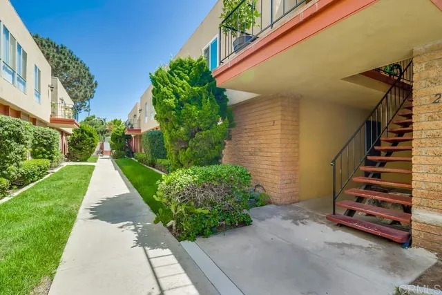 a view of a pathway of a house with flower plants