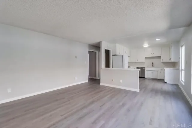 a view of a kitchen with wooden floor and electronic appliances