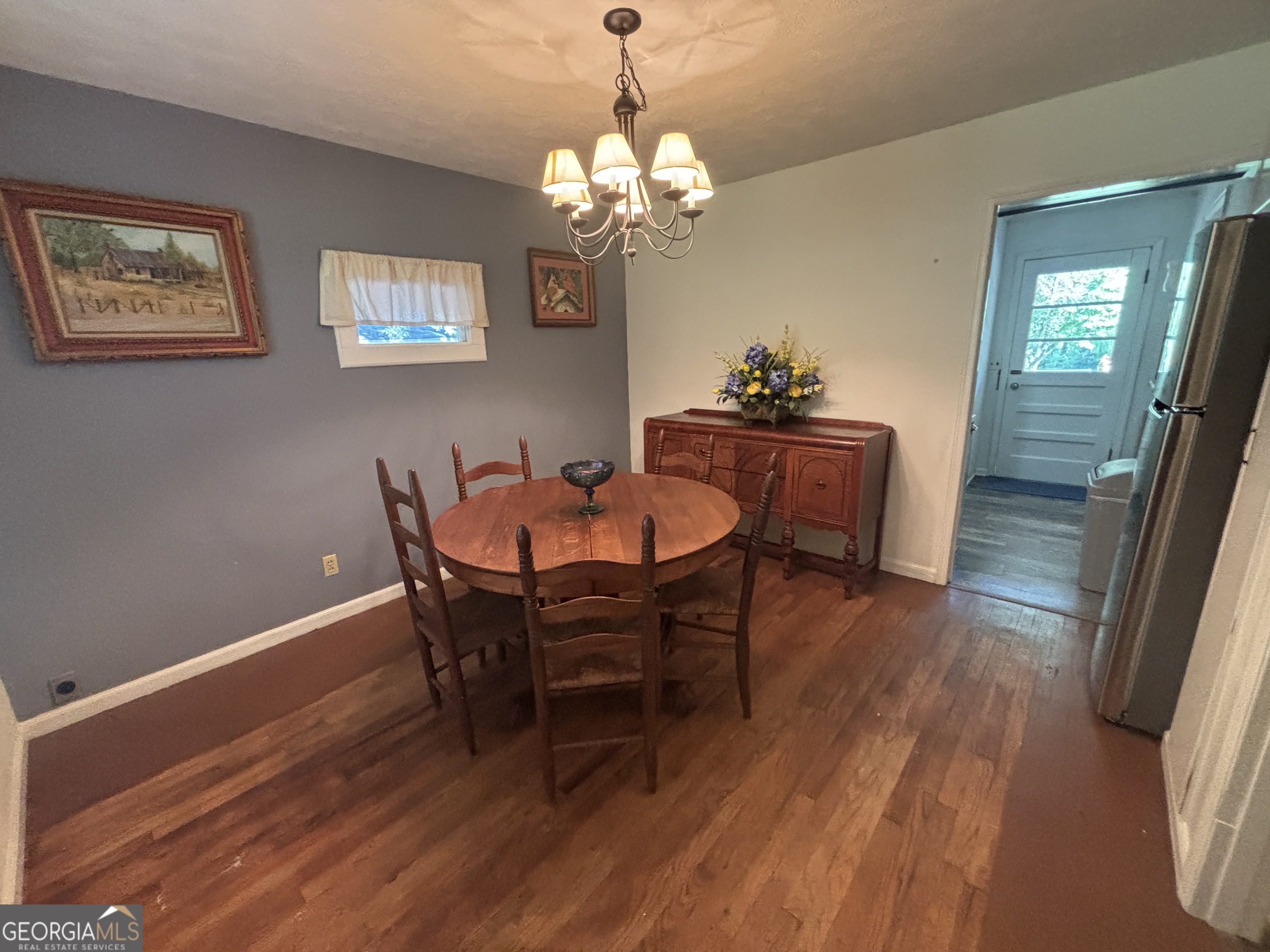 152 Crest Drive Cochran, GA 31014 - Photo 4 of 54 a dining room with wooden floor a chandelier a wooden table and chairs