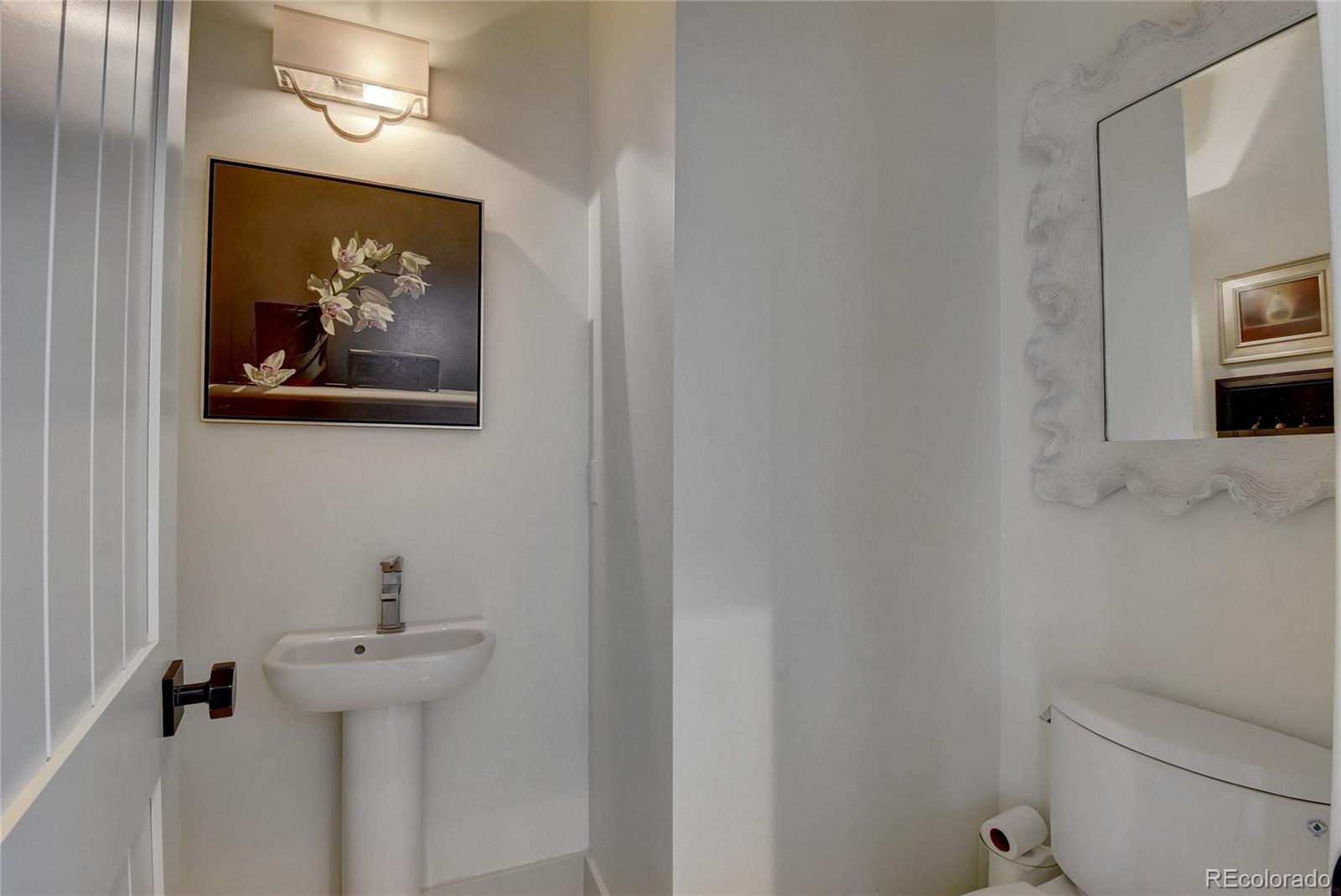 5151 West Wagon Trail Road Littleton, CO 80123 - Photo 11 of 37 a bathroom with a toilet a sink and mirror