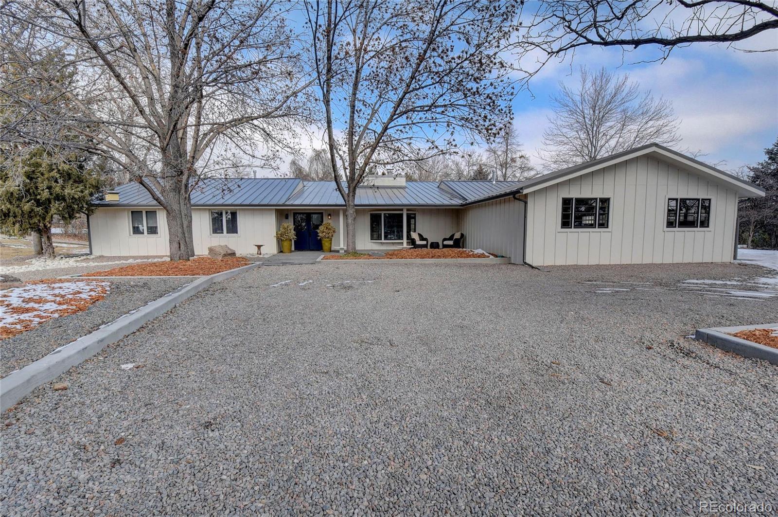 5151 West Wagon Trail Road Littleton, CO 80123 - Photo 2 of 37 a front view of a house with a yard and garage
