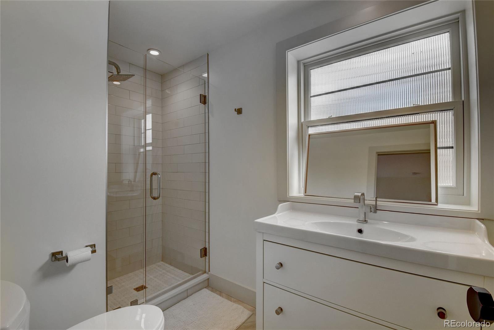 5151 West Wagon Trail Road Littleton, CO 80123 - Photo 23 of 37 a bathroom with a shower sink and mirror