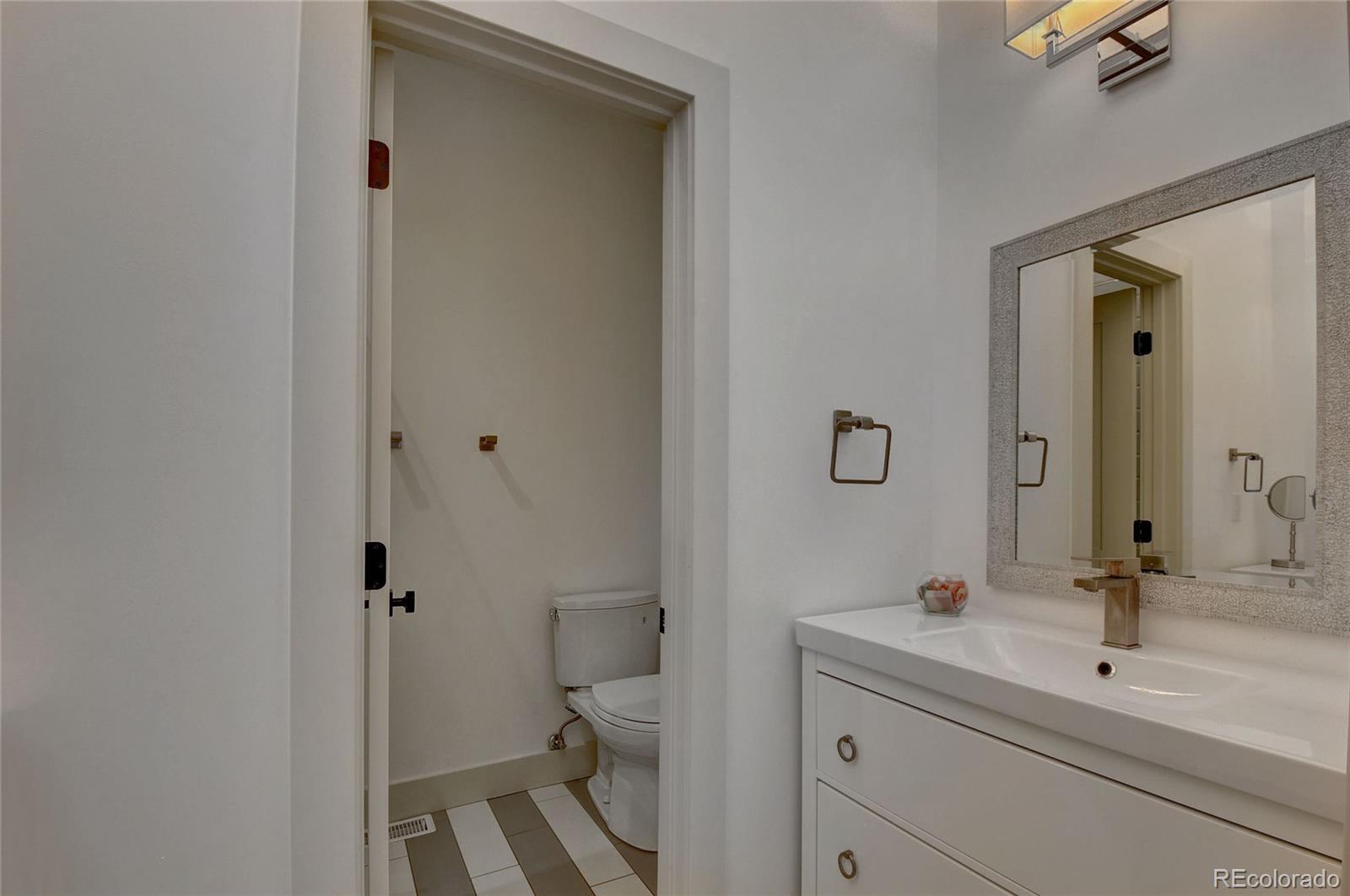 5151 West Wagon Trail Road Littleton, CO 80123 - Photo 27 of 37 a bathroom with a sink and mirror with toilet