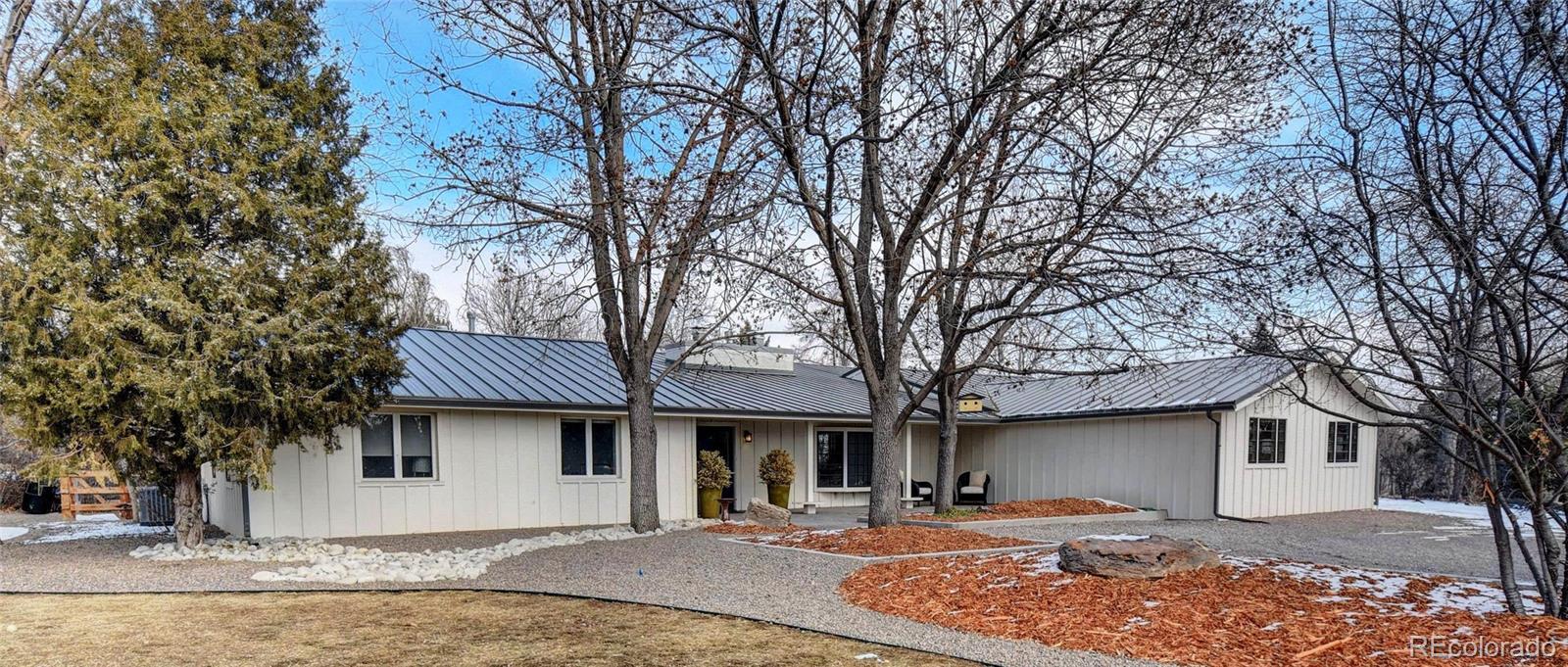 5151 West Wagon Trail Road Littleton, CO 80123 - Photo 3 of 37 a front view of a house with garden