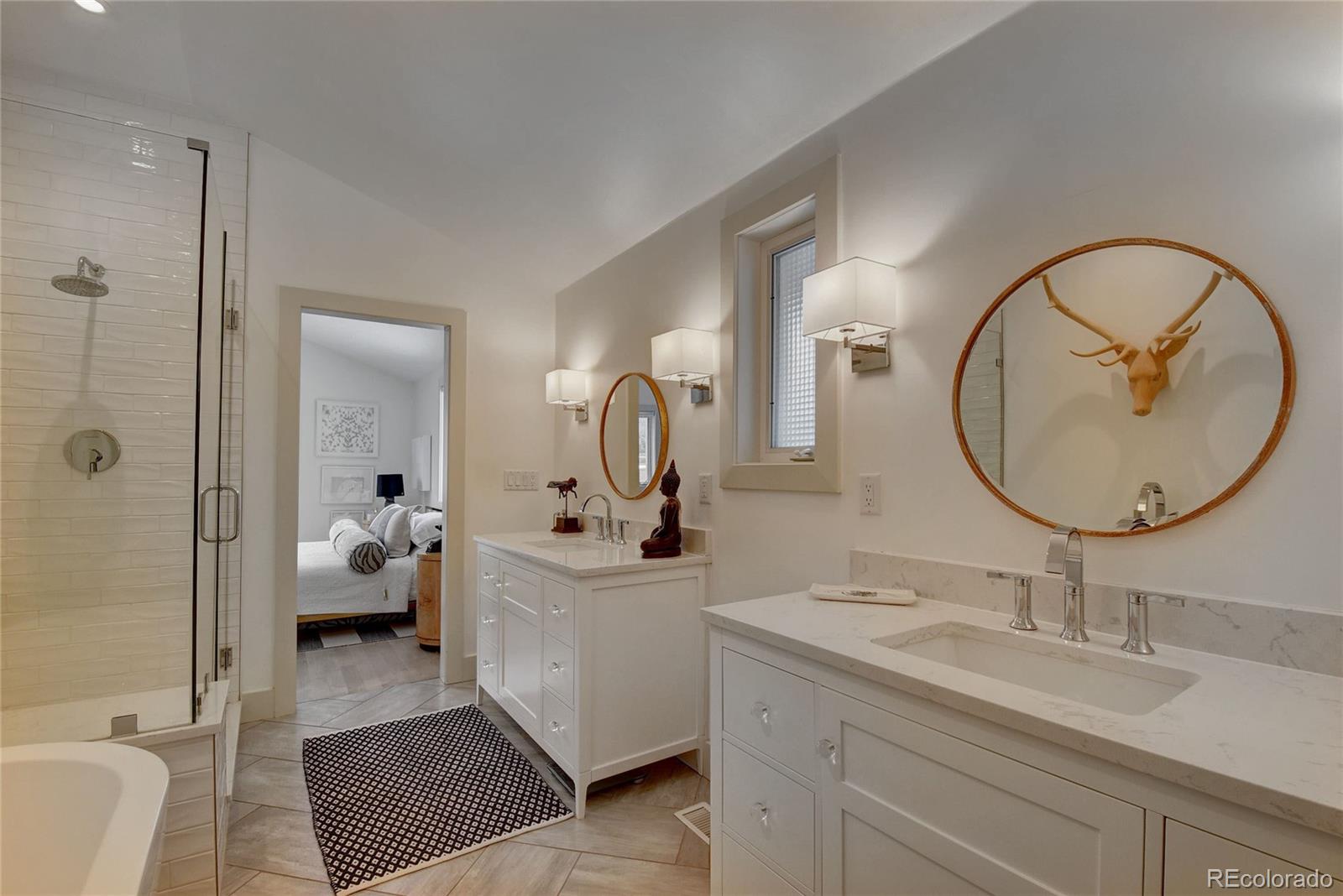 5151 West Wagon Trail Road Littleton, CO 80123 - Photo 32 of 37 a en suite bathroom with a double vanity sink and a mirror