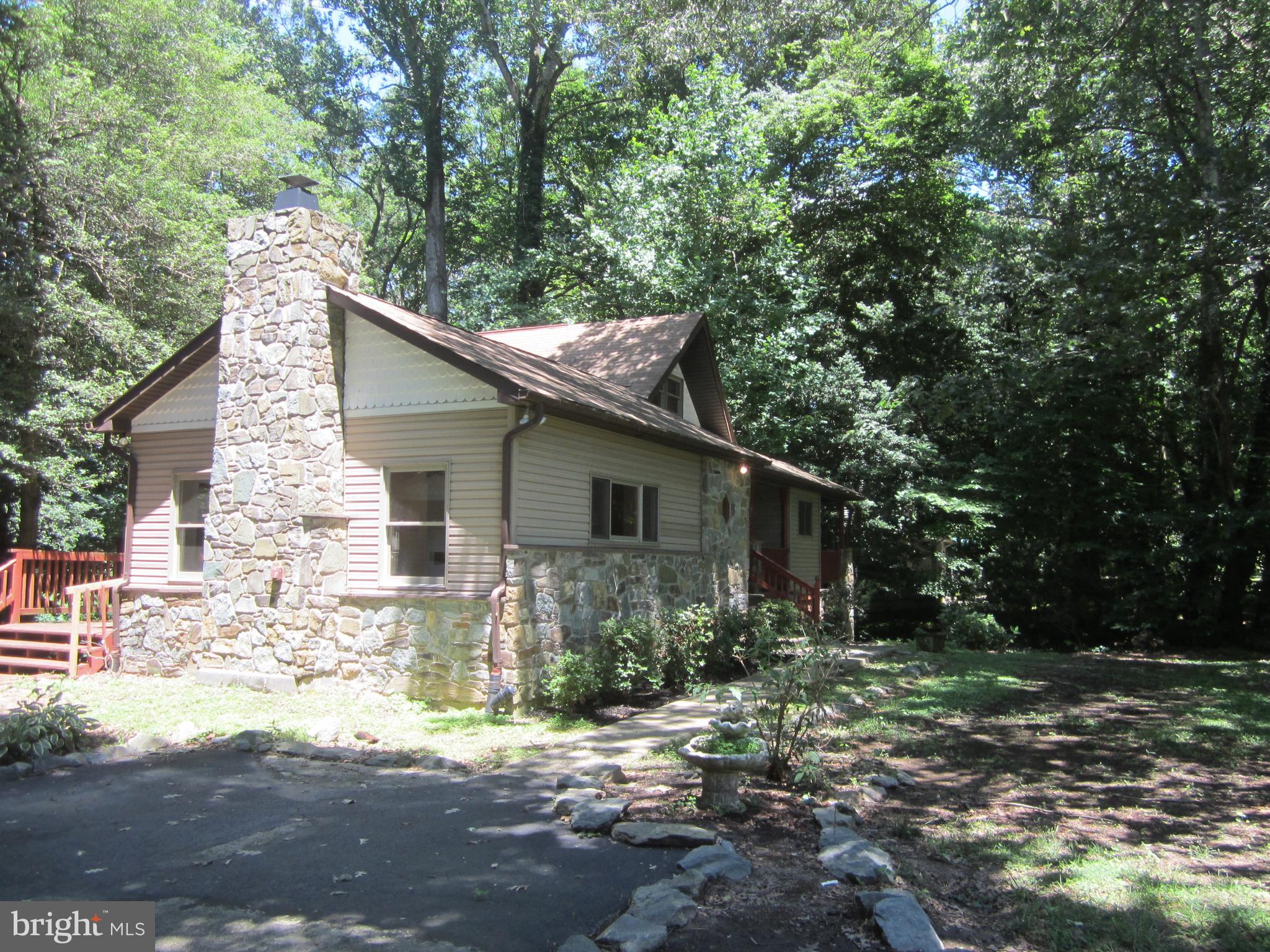 3421 Holland Cliffs Road Huntingtown, MD 20639 - Photo 1 of 19 a backyard of a house with large trees and outdoor seating