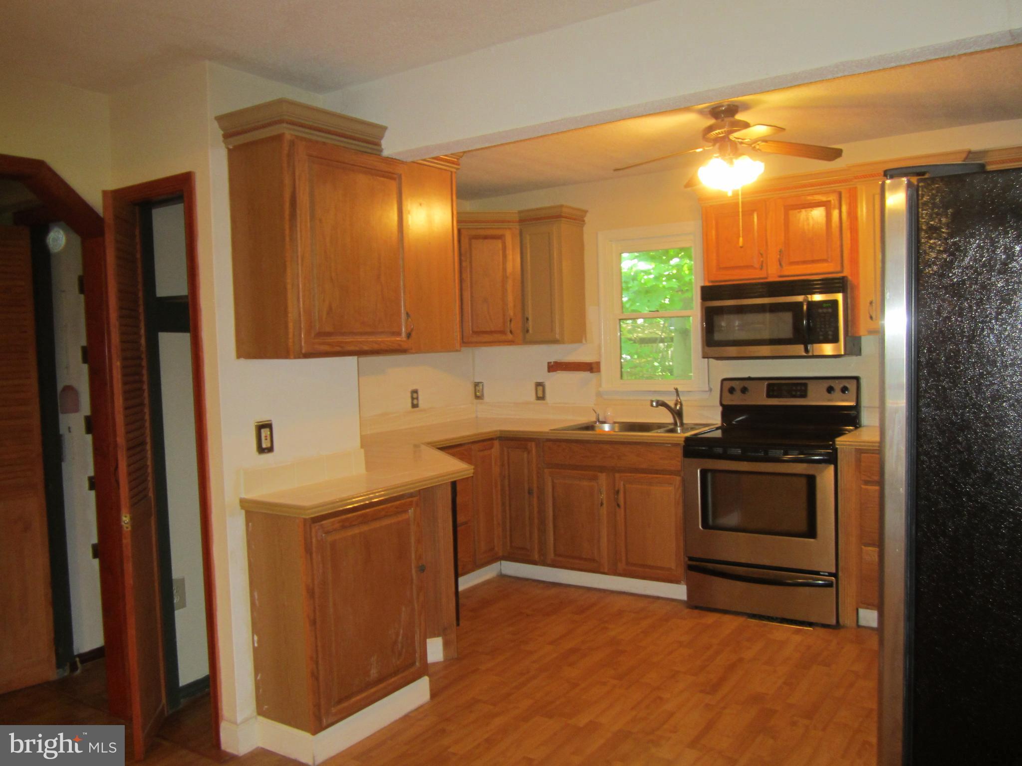 3421 Holland Cliffs Road Huntingtown, MD 20639 - Photo 3 of 19 a kitchen with stainless steel appliances granite countertop a stove and a refrigerator