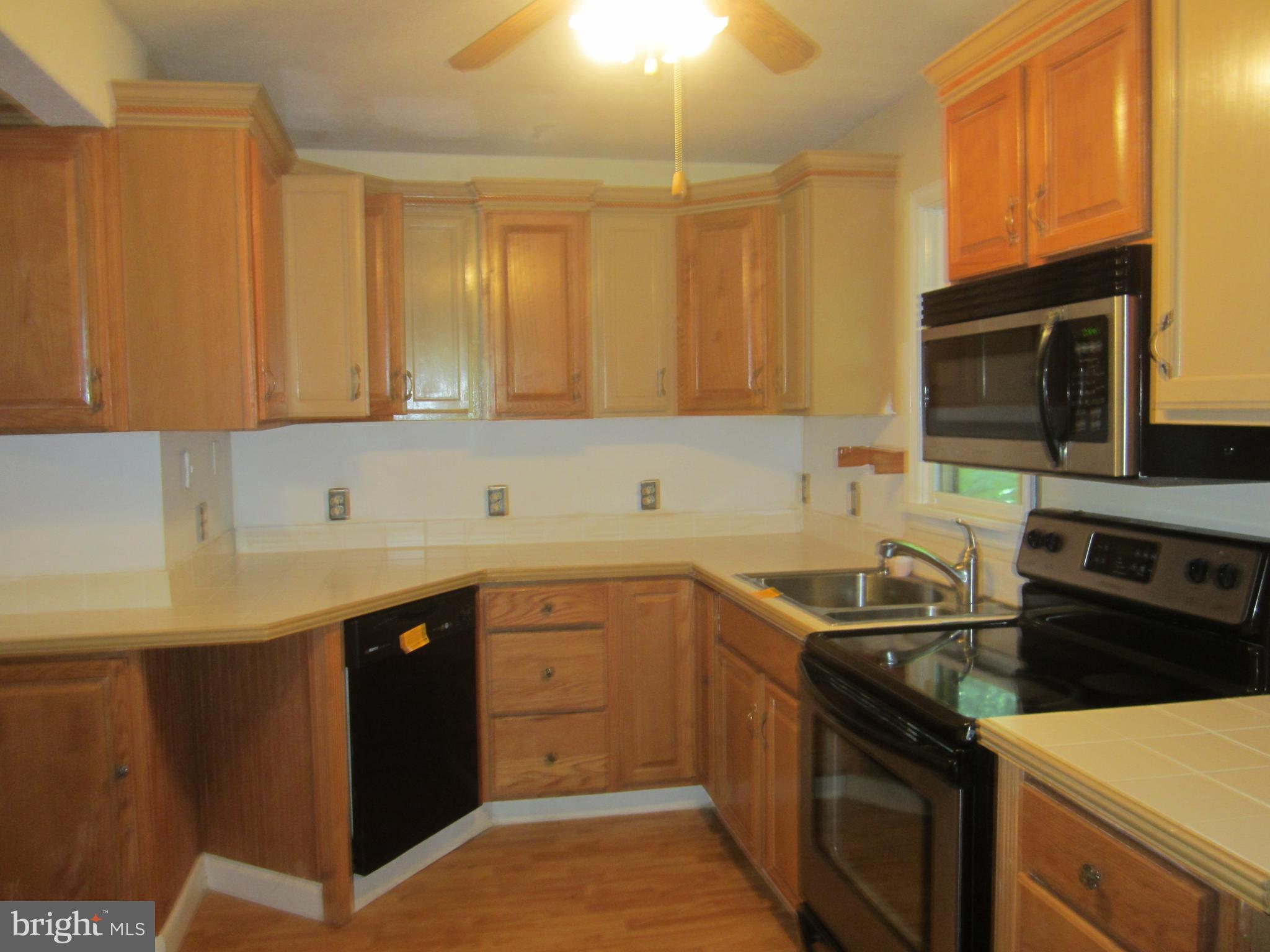 3421 Holland Cliffs Road Huntingtown, MD 20639 - Photo 4 of 19 a kitchen with stainless steel appliances granite countertop a sink stove and microwave