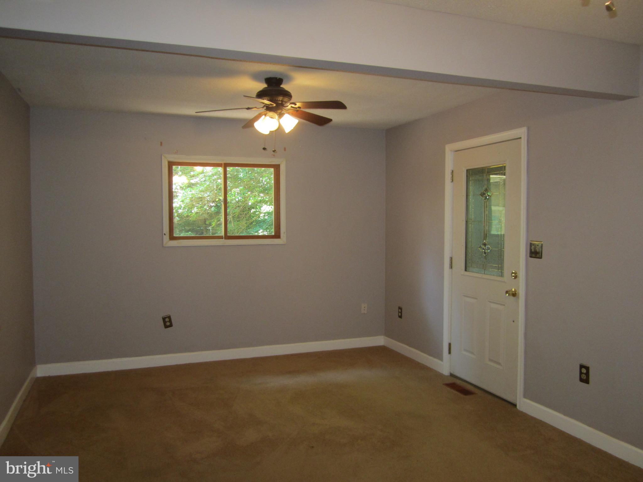 3421 Holland Cliffs Road Huntingtown, MD 20639 - Photo 6 of 19 an empty room with windows and fan