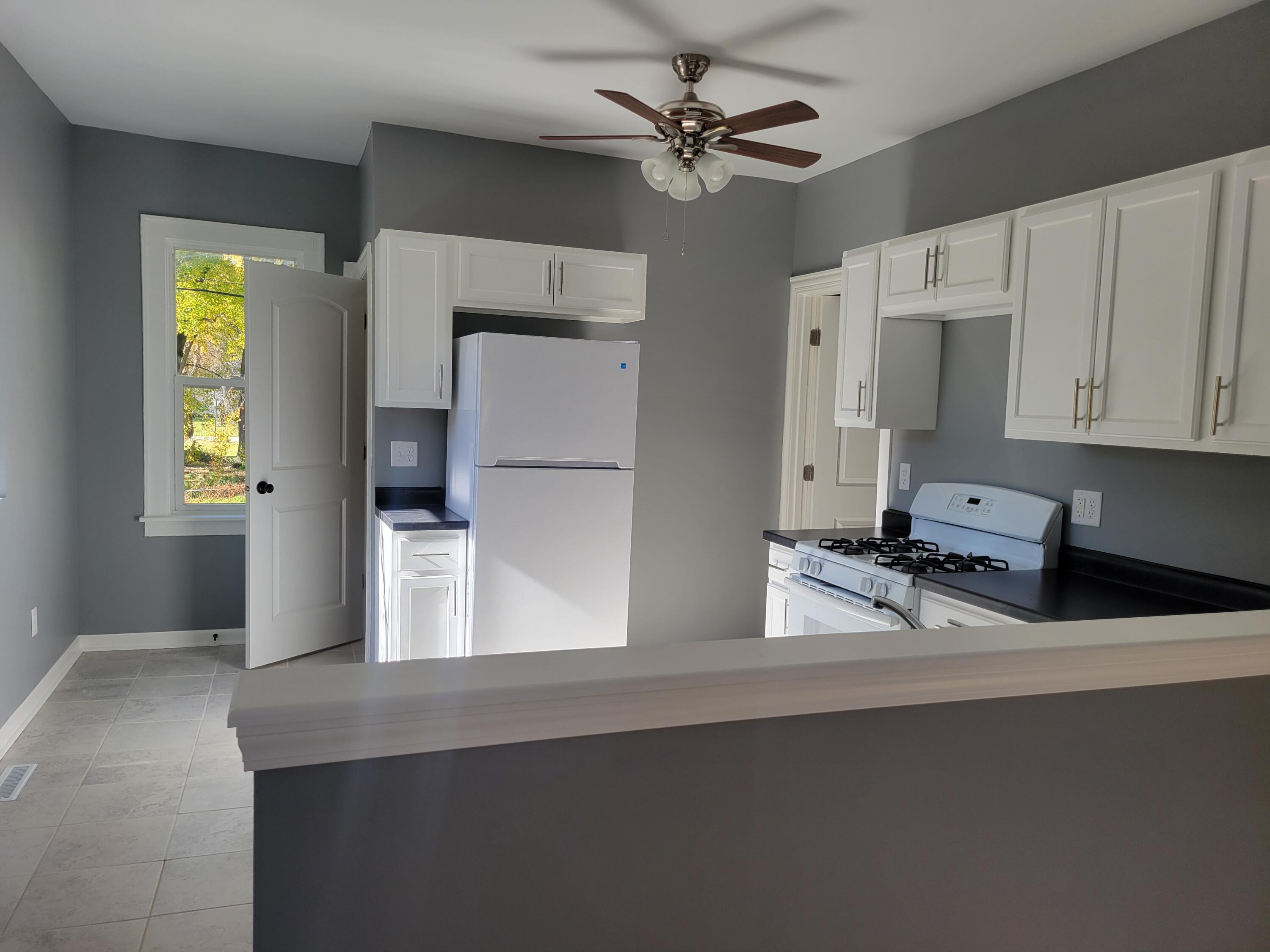 4738 Delaware Street Gary, IN 46409 - Photo 4 of 14 a kitchen with stainless steel appliances a sink a refrigerator and cabinets