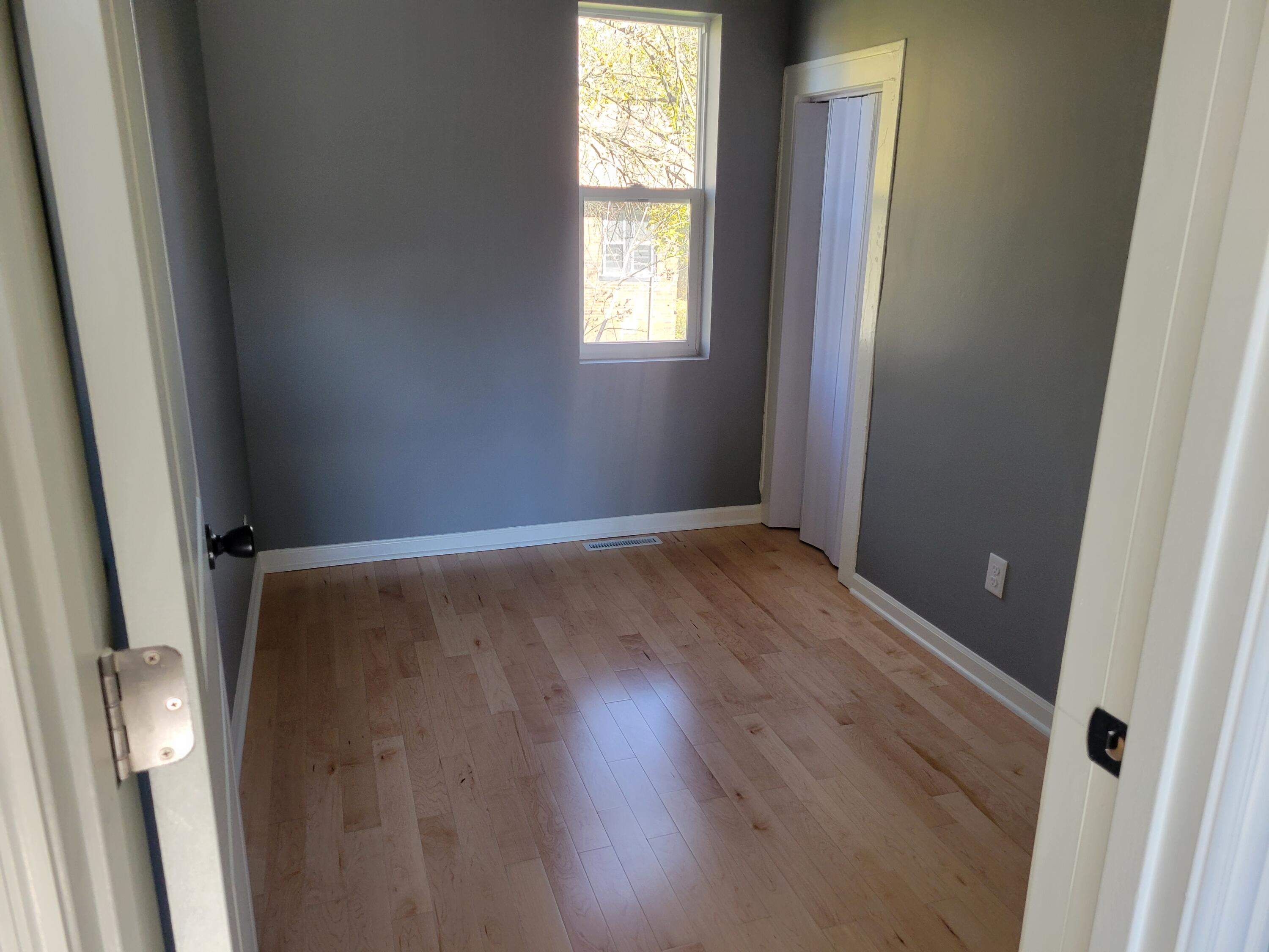 4738 Delaware Street Gary, IN 46409 - Photo 10 of 14 an empty room with wooden floor and windows