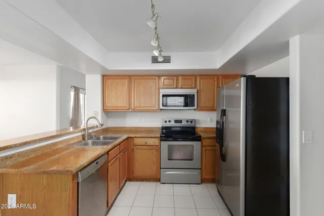 a kitchen with stainless steel appliances a stove sink and refrigerator