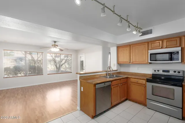 a kitchen with stainless steel appliances granite countertop a stove a sink and a microwave