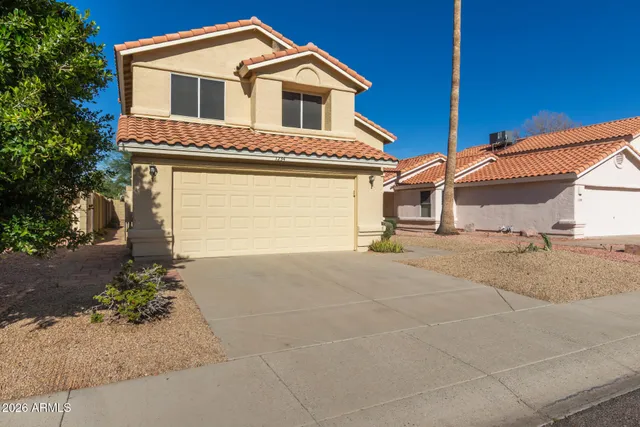 a view of a white house with a yard and garage