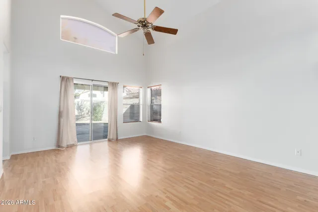 a view of a livingroom with wooden floor and a ceiling fan