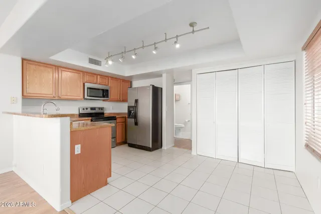 a kitchen with stainless steel appliances granite countertop a refrigerator and a stove top oven
