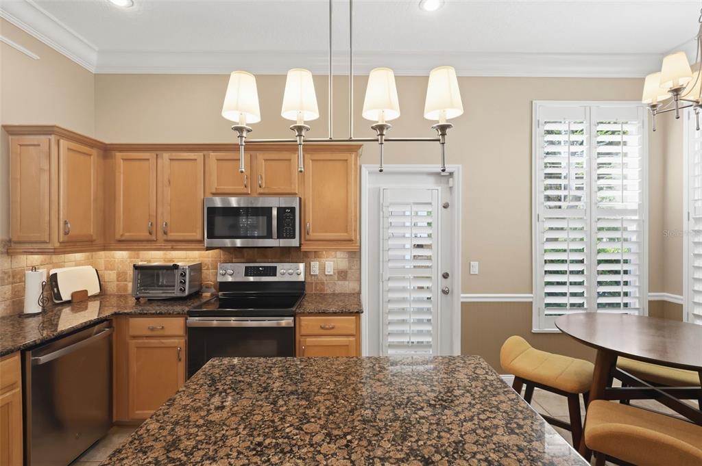 907 Pawstand Road Celebration, FL 34747 - Photo 20 of 49 a kitchen with stainless steel appliances kitchen island granite countertop a stove top oven a sink dishwasher and granite countertops with cabinets