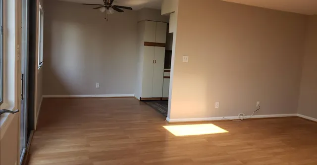 an empty room with wooden floor and a window