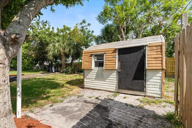 a view of a backyard with table and chairs under an umbrella with wooden fence
