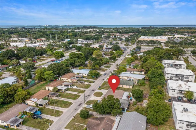 an aerial view of residential houses with outdoor space and trees