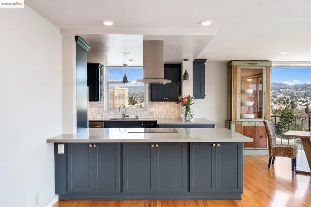 a kitchen with stainless steel appliances a dining table chairs refrigerator and sink