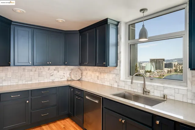 a kitchen with kitchen island a counter top space a sink stainless steel appliances and cabinets