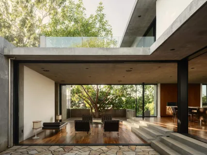 a living room with furniture a large window and wooden floor