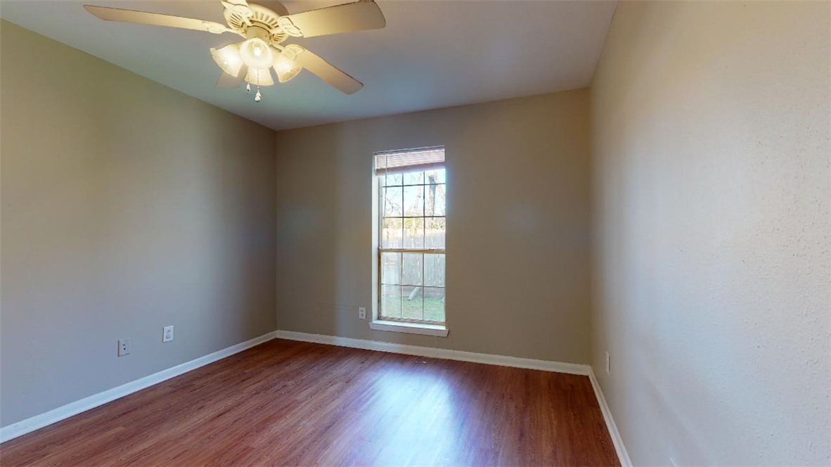 1511 Hollow Hill Drive, Unit B Bryan, TX 77802 - Photo 12 of 22 a view of an empty room with wooden floor and a window