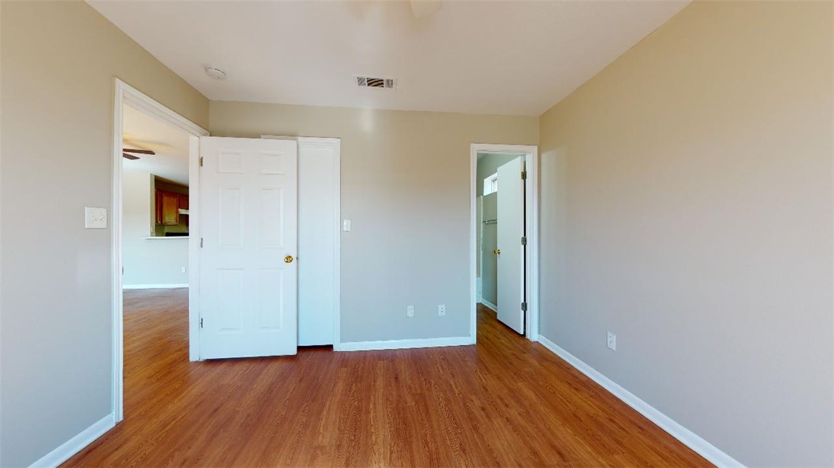 1511 Hollow Hill Drive, Unit B Bryan, TX 77802 - Photo 16 of 22 an empty room with wooden floor and windows