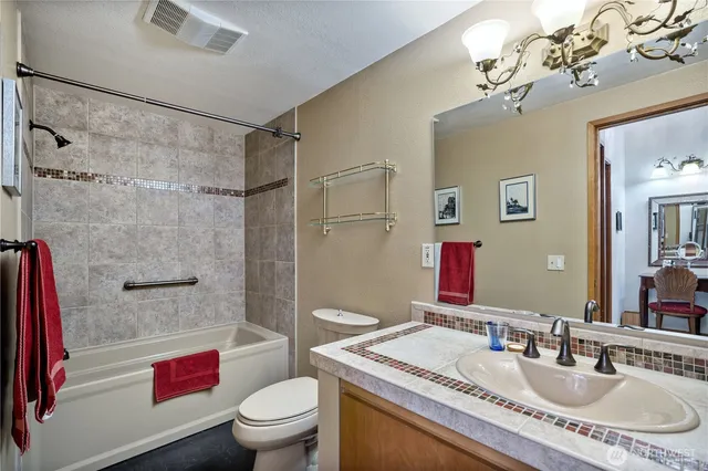 a bathroom with a sink toilet tub and shower